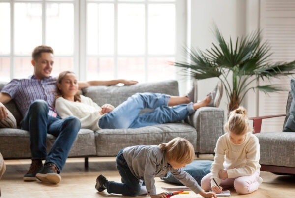 Family sitting in living room with kids playing on the floor